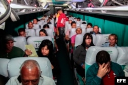 Cubanos en tránsito hacia EEUU son trasladados en un autobús a la salida del Aeropuerto Internacional Monseñor Oscar Arnulfo Romero.