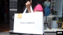 Una clienta pasa con una bolsa de la firma de moda Dolce & Gabbana.