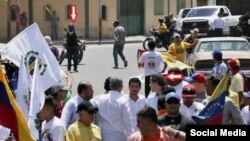 Colectivos apuntando con un arma a la caravana de Juan Guaidó