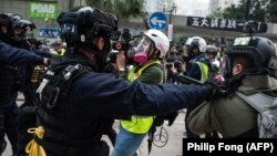 Policías en Hong Kong empujan a periodistas en la manifestación anticomunista del 19 de enero de 2020 (Foto: Archivo/Philip Fong/AFP)