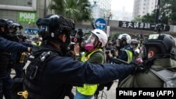 Policías en Hong Kong empujan a periodistas en la manifestación anticomunista del 19 de enero de 2020