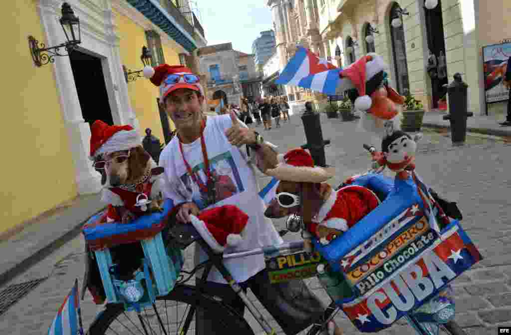 Un hombre con su perro en una calle de La Habana vende mercancía alegórica a la Navidad.