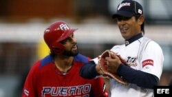 El puertorriqueño Angel Pagan (izda) conversa con el japonés Atsunori Inaba durante el partido que les enfrentó a Puerto Rico en el Clásico Mundial de Béisbol 2013