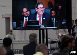 Periodistas en la sala de prensa de la VIII Cumbre de las Américas en Lima siguen la intervención del canciller cubano, Bruno Rodríguez.