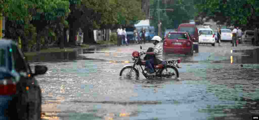 Un hombre conduce una motocicleta por una calle inundada el miércoles en La Habana