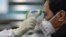 Un miembro de los servicios médicos chequea la temperatura de un paciente en un hospital de Wuhan, epicentro de la epidemia del coronavirus, el 25 de enero del 2020.