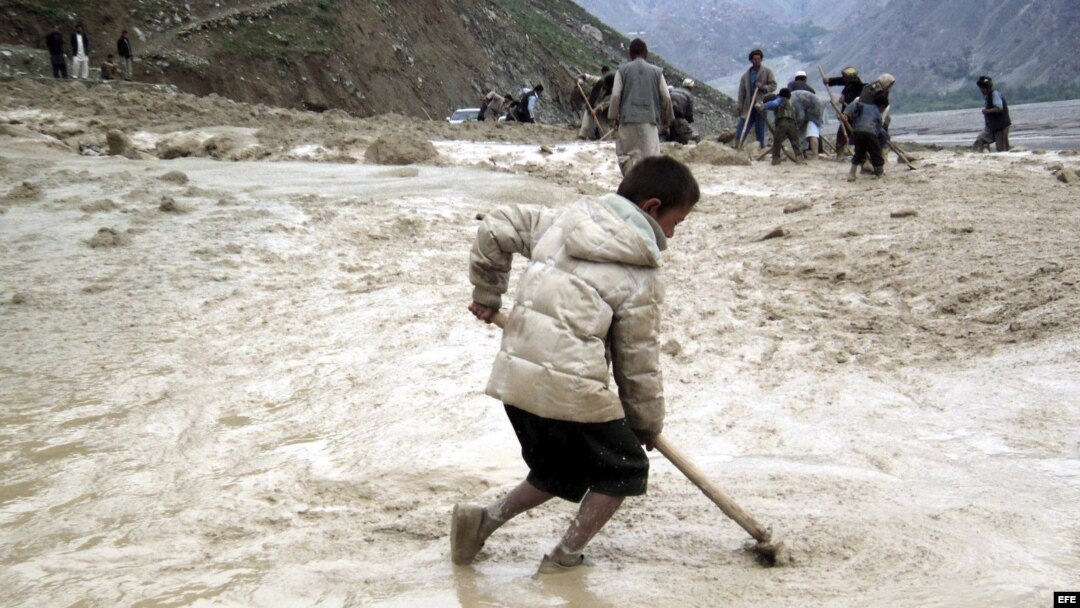 Fotografía de archivo fechada el 30 de abril de 2012 que muestra a varias personas intentando limpiar de barro una carretera tras una lluvia torrencial seguida de un corrimiento de tierra en la provincia de Badakhshan, en Afganistán.