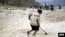 Fotografía de archivo fechada el 30 de abril de 2012 que muestra a varias personas intentando limpiar de barro una carretera tras una lluvia torrencial seguida de un corrimiento de tierra en la provincia de Badakhshan, en Afganistán.