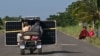 Cubanos transportan un panel solar en un triciclo por una carretera en la provincia de Pinar del Río, el 26 de julio de 2026. (Foto de YAMIL LAGE / AFP)