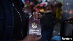 Una doctora cubana muestra su pasaporte oficial en el Aeropuerto Internacional La Aurora, antes de salir de Guatemala tras la finalización del convenio con ese país.