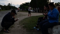 Cubanos chequean sus teléfonos durante un apagón en Matanzas.