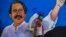 Un indigente pasa frente a un cartel del presidente de Nicaragua, Daniel Ortega, en Managua, el 9 de abril del 2020.