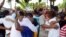 Fieles de la Iglesia "Fuego y Dinámica" en Camagüey se abrazan en el primer servicio después que las autoridades derribaran el cobertizo que habían levantado para practicar su religión.