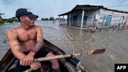 Un hombre navega en un bote de madera en una calle inundada tras el paso del huracán Helene en Guanimar, provincia de Artemisa, Cuba, el 25 de septiembre de 2024.