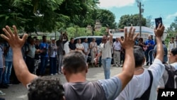 Representantes de varias asociaciones religiosas cubanas guardan a la creadora de contenido y activista cubana Anna Sofía Benítez Silvente y a su madre, Caridad Silvente, a las puertas del Tribunal Municipal de Habana del Este