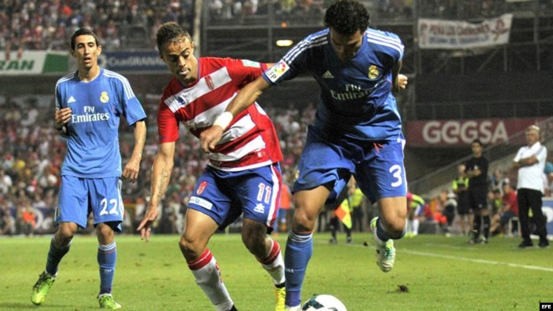 El defensa portugués del Real Madrid Pepe (d) lucha el balón con Dani Benítez, del Granada CF, durante el partido, correspondiente a la segunda jornada de la Liga en Primera División.
