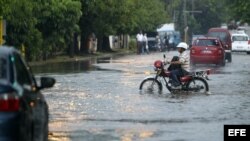 Un hombre conduce una motocicleta por una calle inundada el miércoles en La Habana.