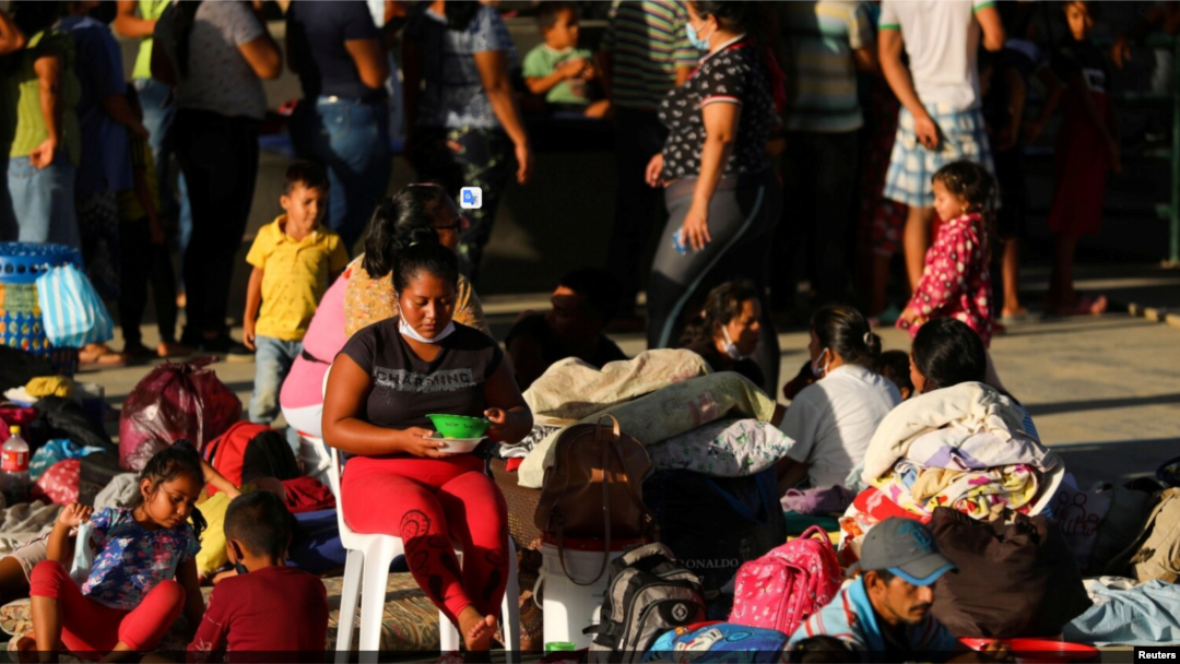 Migrantes venezolanos en Arauquita, Colombia, entre ellos mujeres y menores de edad, acampan en una estación temporal tras enfrentamientos militares en Venezuela en el mes de abril de 2021.