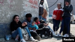 Migrantes procedentes de Cuba permanecen sentados en una acera cerca de la Comisión Mexicana de Ayuda a Refugiados (COMAR), a la espera de regularizar su situación migratoria en el país, en la Ciudad de México, México, el 24 de enero de 2025. REUTERS/Henry Romero