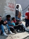 Migrantes procedentes de Cuba permanecen sentados en una acera cerca de la Comisión Mexicana de Ayuda a Refugiados (COMAR), a la espera de regularizar su situación migratoria en el país, en la Ciudad de México, México, el 24 de enero de 2025. REUTERS/Henry Romero