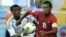El futbolista cubano Olaitan Michail (d) lucha por el control del balón ante el nigeriano Yolexis Collado (i).