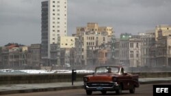 Un viejo auto circula por el malecón de La Habana (Cuba).