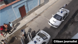 Autos policiales a la puerta del domicilio del periodista independiente guantanamero Roberto Jesús Quiñones (foto del autor).
