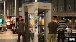 Empleados trasladan un escáner de cuerpo entero por el pasillo de la terminal de salidas del aeropuerto de Hamburgo, Alemania