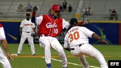 Foto archivo. El holandés Rily Legito (d) saca out al cubano Yuliesky Gourriel de Cuba durante el cuarto juego del Clásico Mundial de Béisbol disputado el 9 de marzo de 2006, en el estadio Hiram Bithorn de San Juan (Puerto Rico).