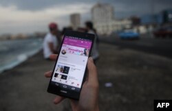 Youtubers cubanos exhiben la conexión a su página en la red social de vídeos, en La Habana. Archivo. AFP.