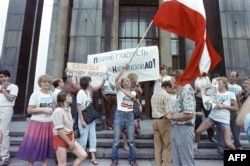 Personas se manifiestan frente a la Biblioteca Lenin de Moscú el 14 de junio de 1988. Algunas exhiben una bandera de Letonia; otras, pancartas con consignas a favor de la "glásnost" . VITALY ARMAND / AFP