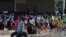 Personas cargan productos saqueados a tiendas hoy en el puerto de Acapulco (México), tras el paso del huracán Manuel