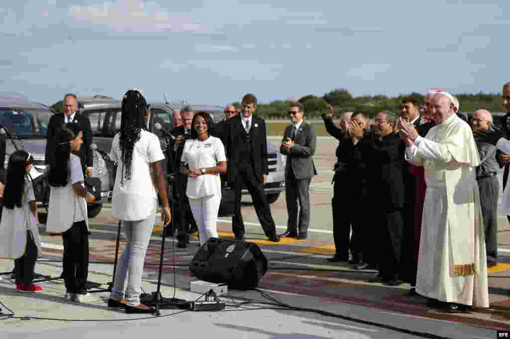 El papa Francisco es recibido por un coro de niños a su llegada al aeropuerto de Santiago de Cuba. 