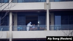 Peter Ben Embarek, experto en virus de la OMS, miembro del equipo de la Organización Mundial de la Salud encargado de investigar los orígenes de la enfermedad del coronavirus, recibe una prueba de hisopo en el balcón de un hotel de Wuhan, provincia de Hub.