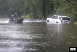 Rescatistas acuden en auxilio de personas atrapadas en auto en una calle inundada de Latta, Carolina del Sur.