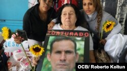 Amelia García, madre de José Daniel Ferrer, sostiene un afiche con la imagen de su hijo durante una manifestación en Miami por su liberación. 