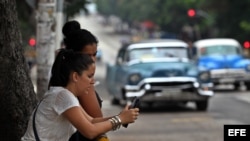Dos mujeres navegan por internet usando una red wifi operada por ETECSA en La Habana. Archivo. EFE.
