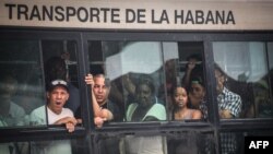 Cubanos viajan en guagua.