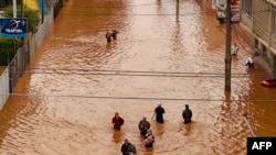 Vista aérea de personas caminando por una calle inundada en el barrio Navegantes en Porto Alegre, estado de Rio da Grande do, Brasil, el 4 de mayo de 2024