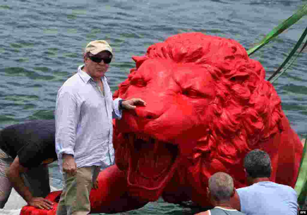 El artista pl&aacute;stico cubano Roberto Fabelo (i) posa junto a un le&oacute;n rojo creado por &eacute;l que conforma la obra "Garras en la piedra" que se instala en los arrecifes del malec&oacute;n de La Habana (Cuba). Esta pieza forma parte 
