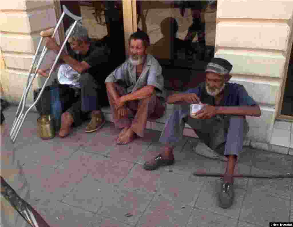 tres indigentes alimentándose en el céntrico boulevard, ubicado en la calle Crombet entre Calixto García y Los Maceos, el que tiene las muletas es un ex combatiente de la guerra de Angola. &nbsp;