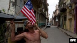 Un cubano besa una bandera norteamericana en una calle de La Habana Vieja. EFE