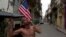 Un cubano besa una bandera norteamericana en una calle de La Habana Vieja. EFE
