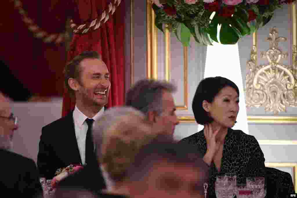 El dj francés David Guetta (i) y la ministra de Cultura y Comunicaciones de Francia, Felur Pellrin asisten durante la a cena en honor a Castro, en el Palacio del Elíseo en París (Francia).