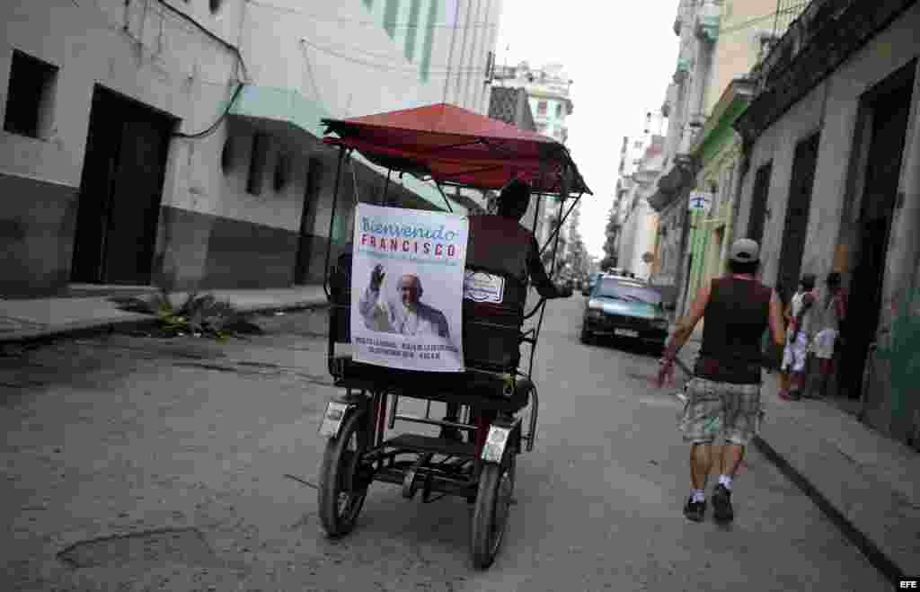 Un bicitaxi circula con un cartel con la imagen del papa Francisco en La Habana. EFE