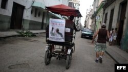 Un bicitaxi circula en La Habana con un cartel con la imagen del papa Francisco. EFE.