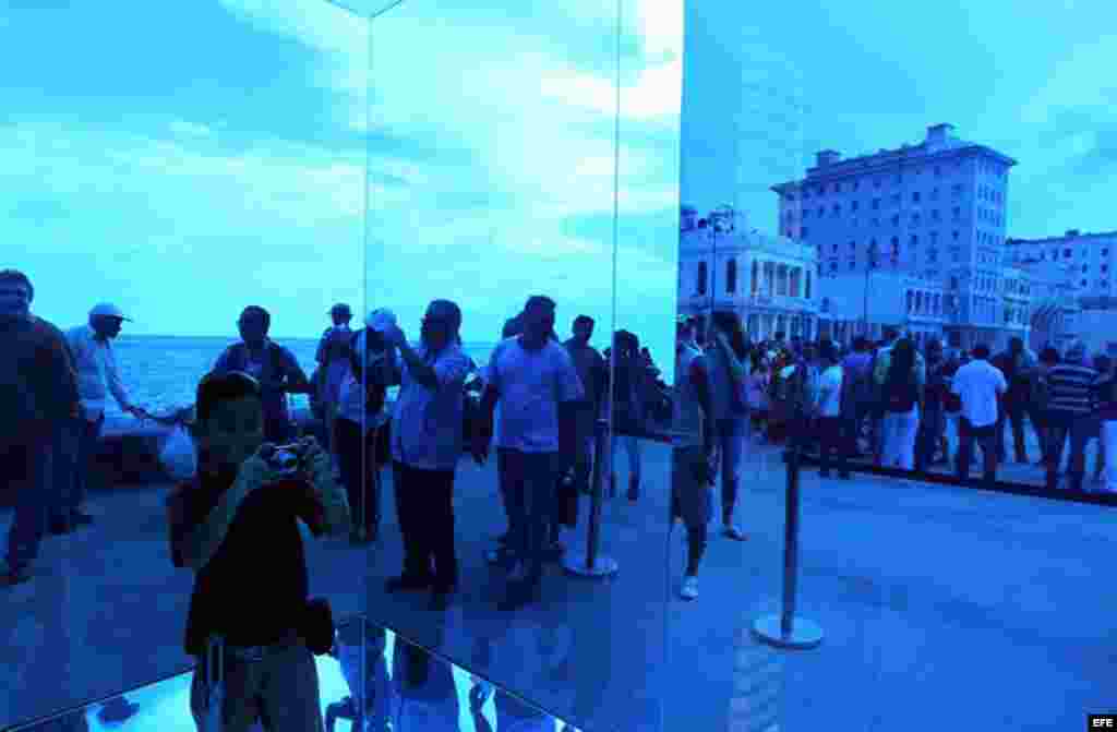 Un niño toma fotos dentro de la obra "Cubo Azul" de la artista Rachel Valdés expuesta en el Malecón hoy, domingo 24 de mayo, donde ha sido inaugurada la exposición "Detrás del Muro" como parte de la XII Bienal de Arte de La Habana.