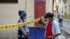 Una oficial de policía exige identificación a un ciudadano en una calle de La Habana cerrada por coronavirus. (YAMIL LAGE / AFP).