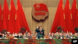 Li Kequiang, en el centro, eleva su mano durante una votación en la Liga de Jóvenes Comunistas, el 10 de mayo de 1993 en Beijing, China. (AP/Greg Baker).