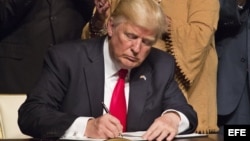 El presidente estadounidense, Donald J. Trump, firma el memorando presidencial sobre la política con Cuba tras finalizar su discurso en el teatro Manuel Artime de la Pequeña Habana, en Miami.